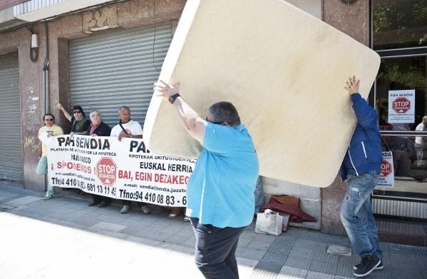 Kaleratutako familia batek gauzak ateratzen ditu etxetik. JON HERNAEZ / ARGAZKI PRESS