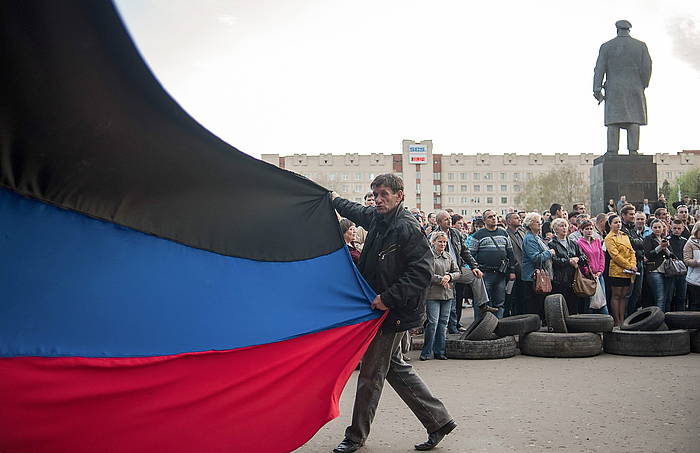 Manifestari bat Donetskeko errepublikako bandera zabaltzen, Slaviansken. ROMAN PILIPEY, EFE