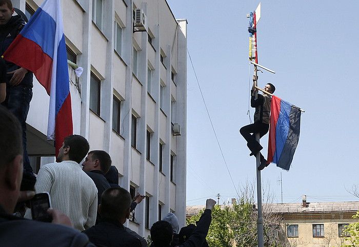 Gazte bat Donetskeko Herri Errepublikaren bandera paratzen, atzo, Mariupoleko udaletxean, eraikina berreskuratu ondotik. MAXIM SHIPENKOV / EFE