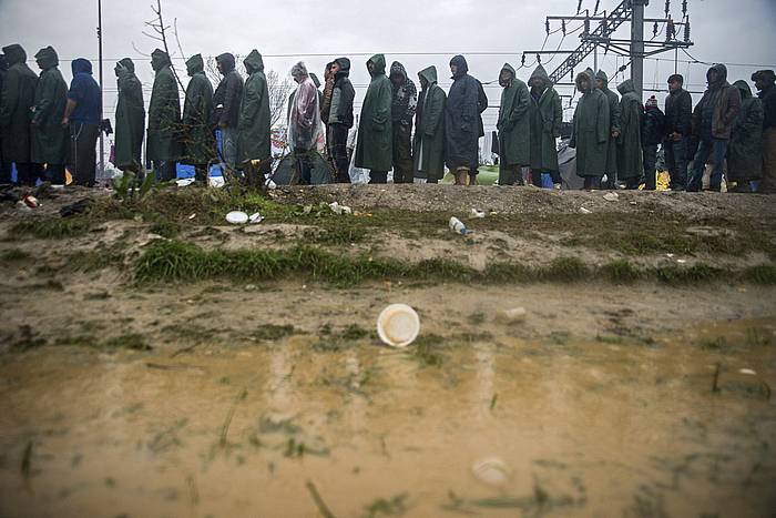 Migratzaileak Idomeniko kanpalekuan (Grezia) tea edateko ilara egiten. ZOLTAN BALOGH / EFE