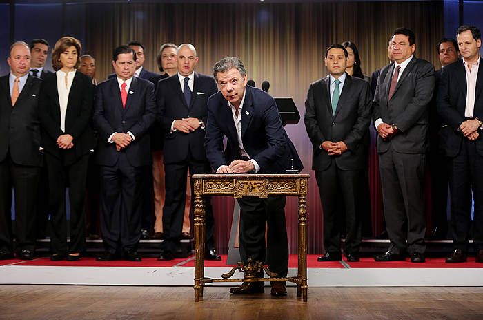 Juan Manuel Santos, dekretua sinatzen, atzean gobernuko ministroak dituela. LEONARDO MUñOZ / EFE