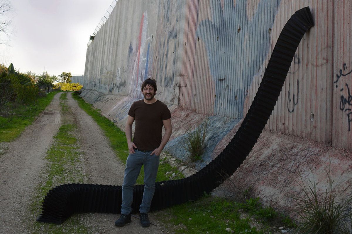 Jose Pablo Arriaga eskultorea, Israelek eraikitako hesiaren ondoan. BERRIA.