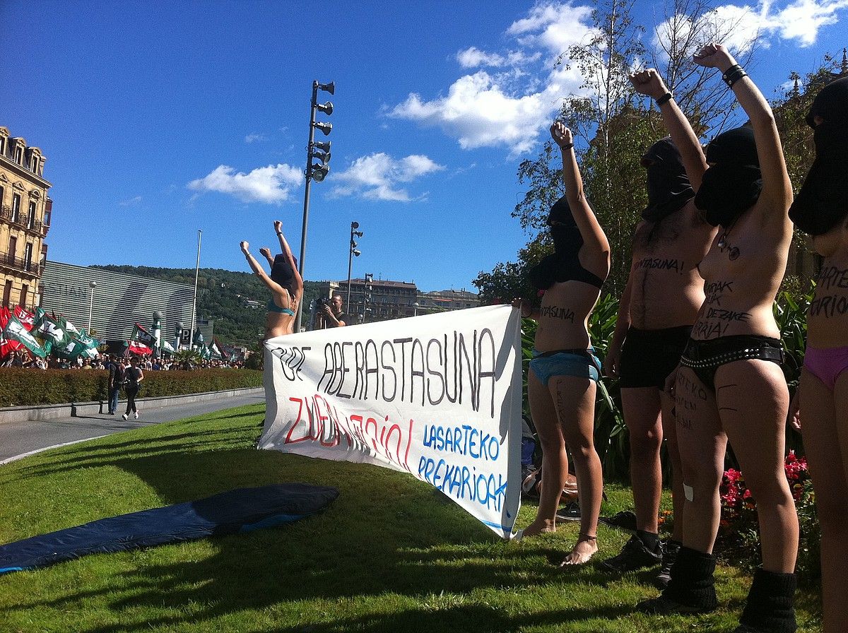 Donostiako manifestazioa Bulebarrera iristen; lorategian, Lasarteko Prekarioak taldeko kideak ia biluzik, ukabil ezkerra altxatuta. XABIER MARTIN.