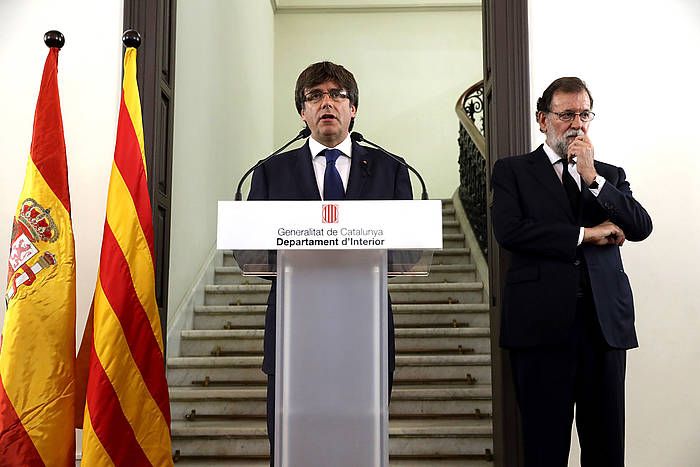 Carles Puigdemont hizketan, atentatuen biharamunean, atzean Mariano Rajoy duela. SERGIO BARRENECHEA / EFE