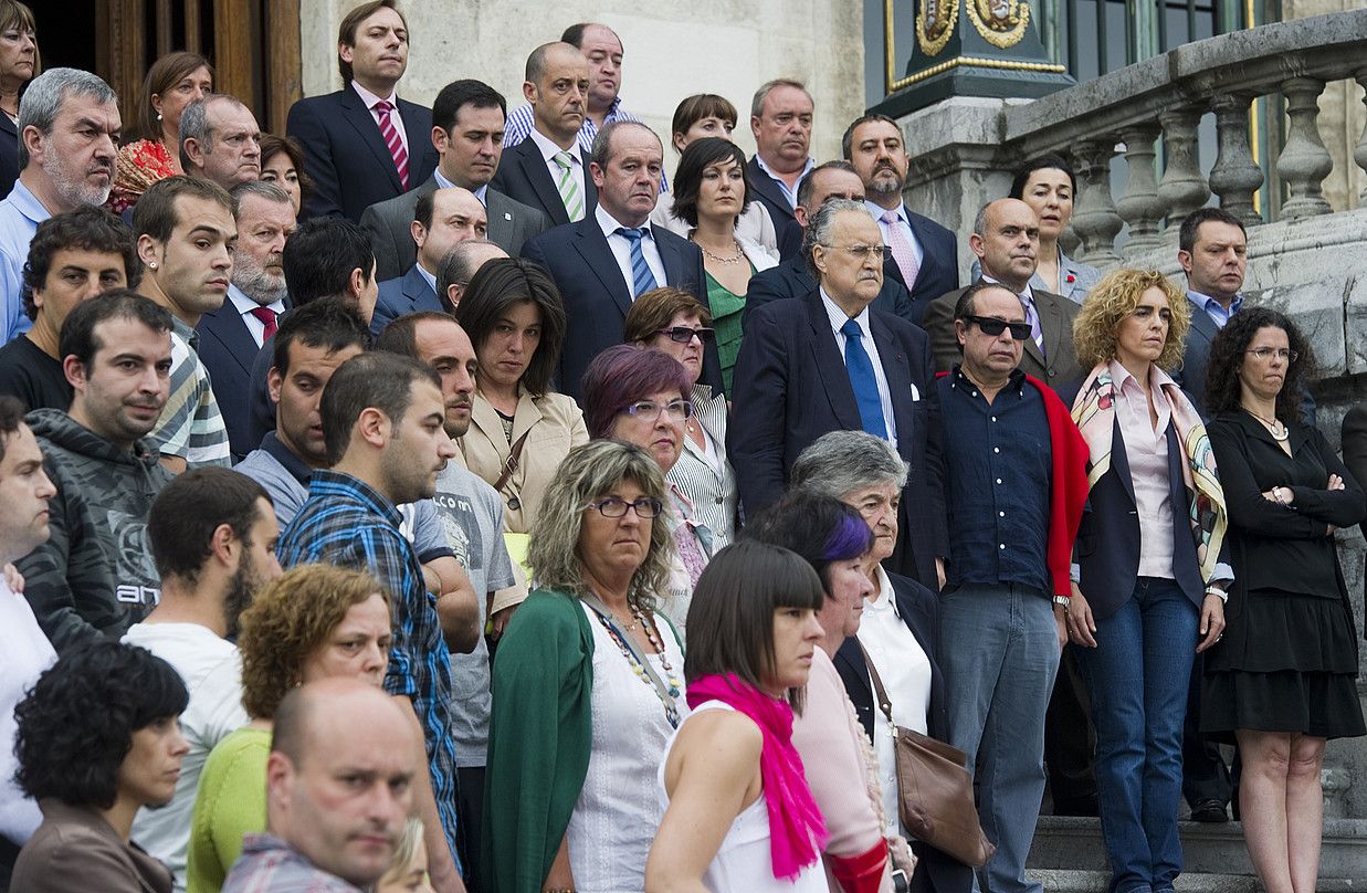 Bilboko udaletxeko atarian atzo egindako elkarretaratzea. Iñaki Azkuna alkatearen ezker-eskuin, Iñigo Cabacas gazte zenduaren gurasoak ageri dira. LUIS JAUREGIALTZO / ARGAZKI PRESS.