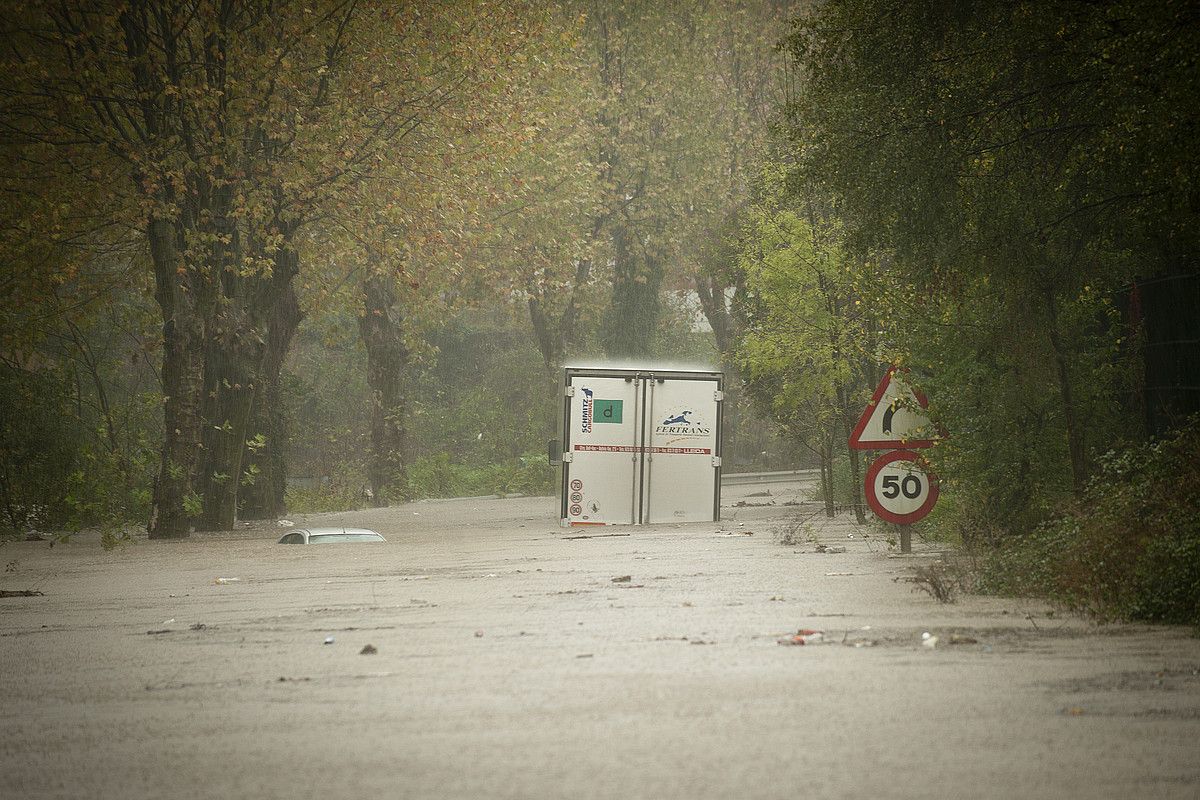 Hernani. Txalakako bidea, urak erabat estalita, azaroaren 6ko argazki batean; auto baten goiko aldea ozta-ozta ageri da. Eskuinean, herenegungo argazki bat. GARI GARAIALDE / ARP.