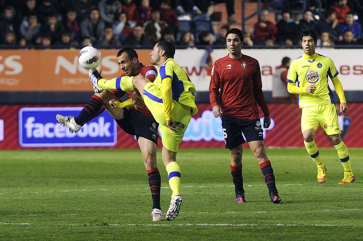 Patxi Puñal Osasunakoa Getafeko jokalari batekin lehian, atzoko partidan; atzean, begira, Javad Nekunam ageri da. IÑIGO URIZ / ARGAZKI PRESS.