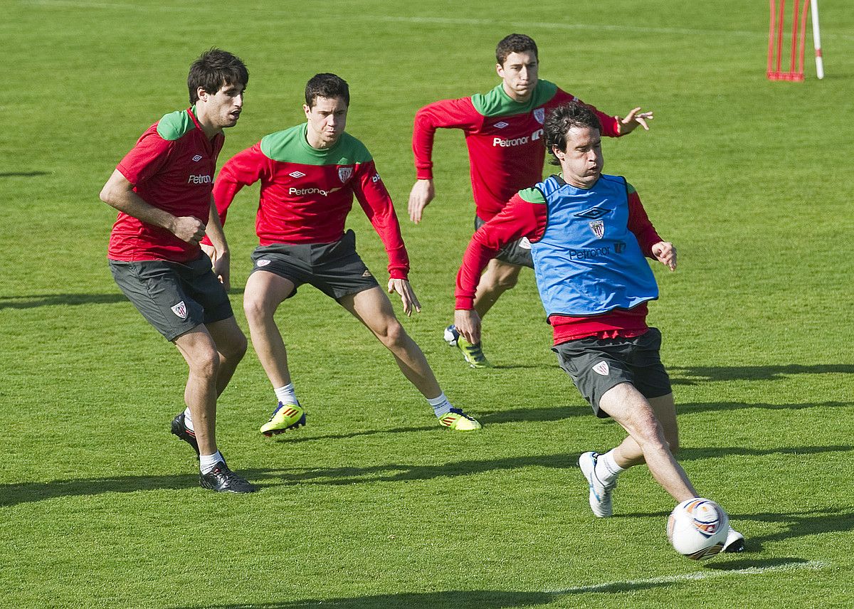 Athleticeko hiru jokalari David Lopez estutzen, entrenamendu batean. ARP.