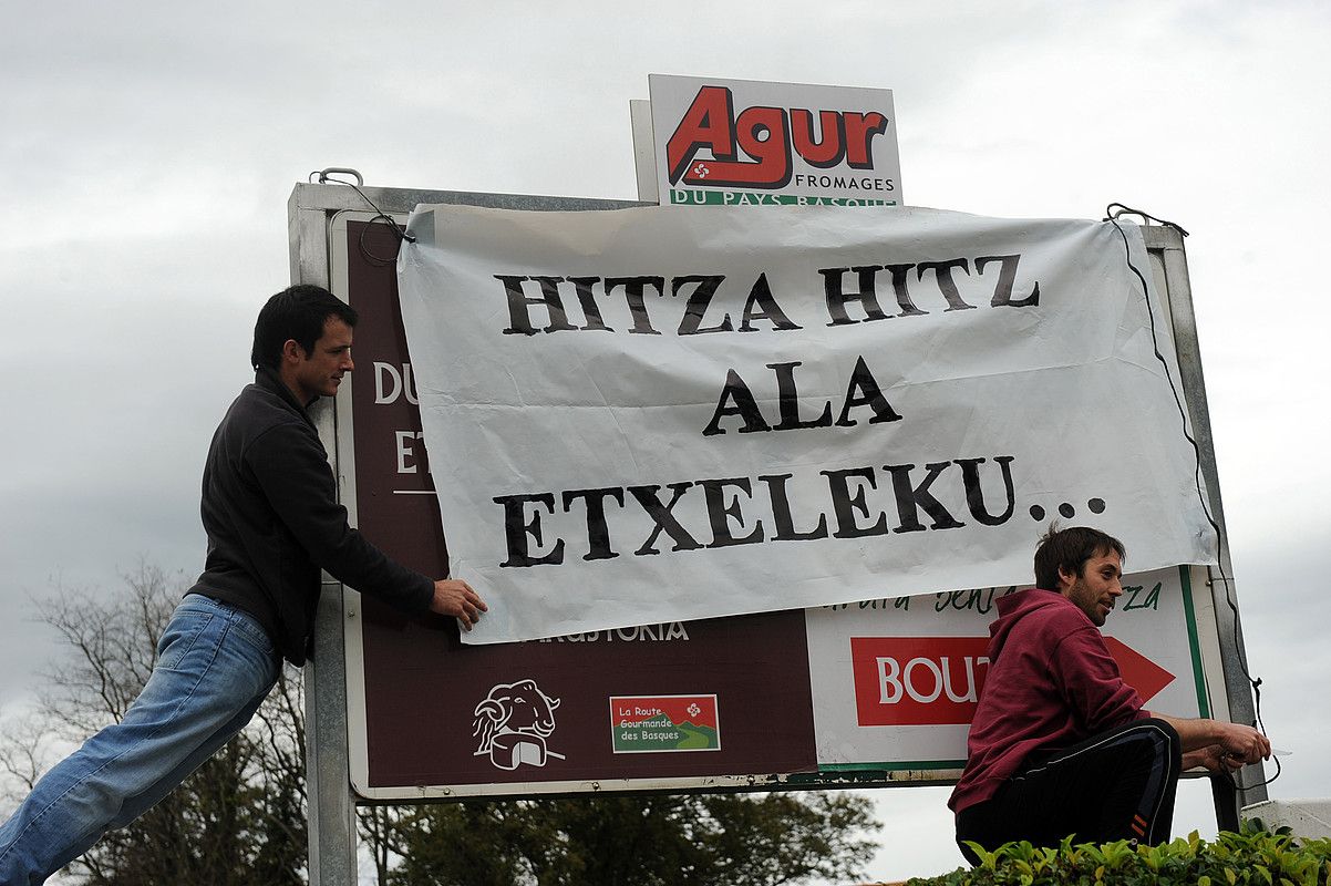 ELBko kideak, Agour esnetegiaren sarrerako afitxa estaltzen, atzo, Heletan. GAIZKA IROZ.