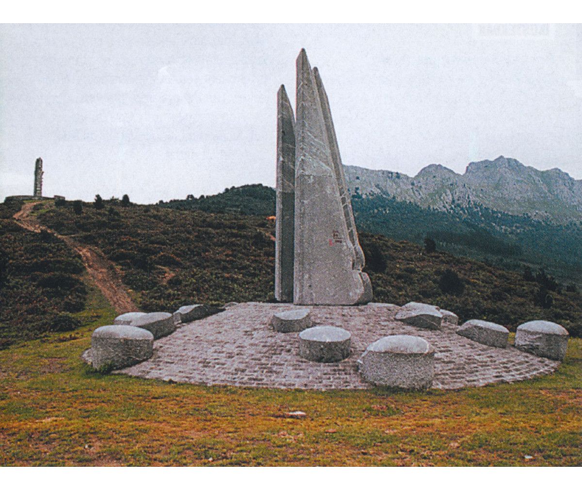 Besaideko bi monumentuak, Ogatarena aurrean eta Pueyorena atzean, Udalaitz magalean. BERRIA.