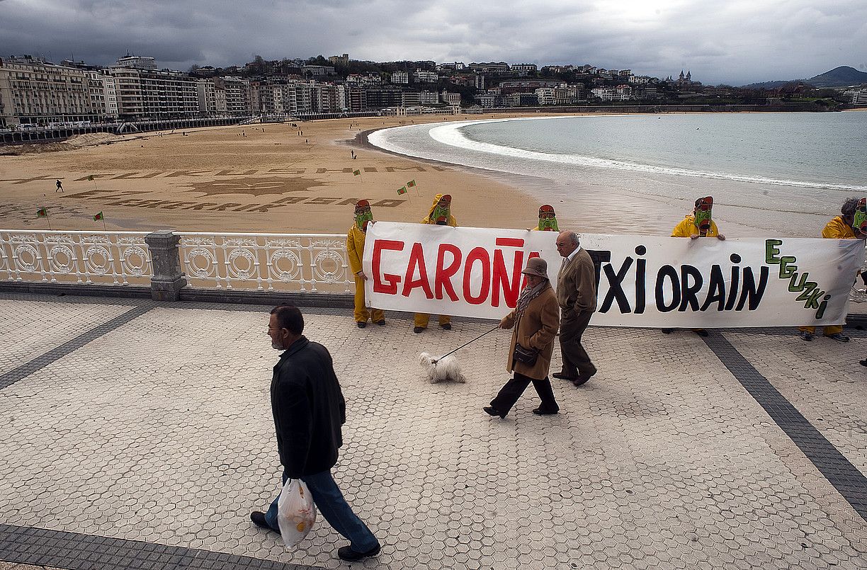 Eguzkikoak protestan, atzo, Donostian, Kontxan. Ikur antinuklearra marraztu zuten hondartzan. J.C.RUIZ / ARP.