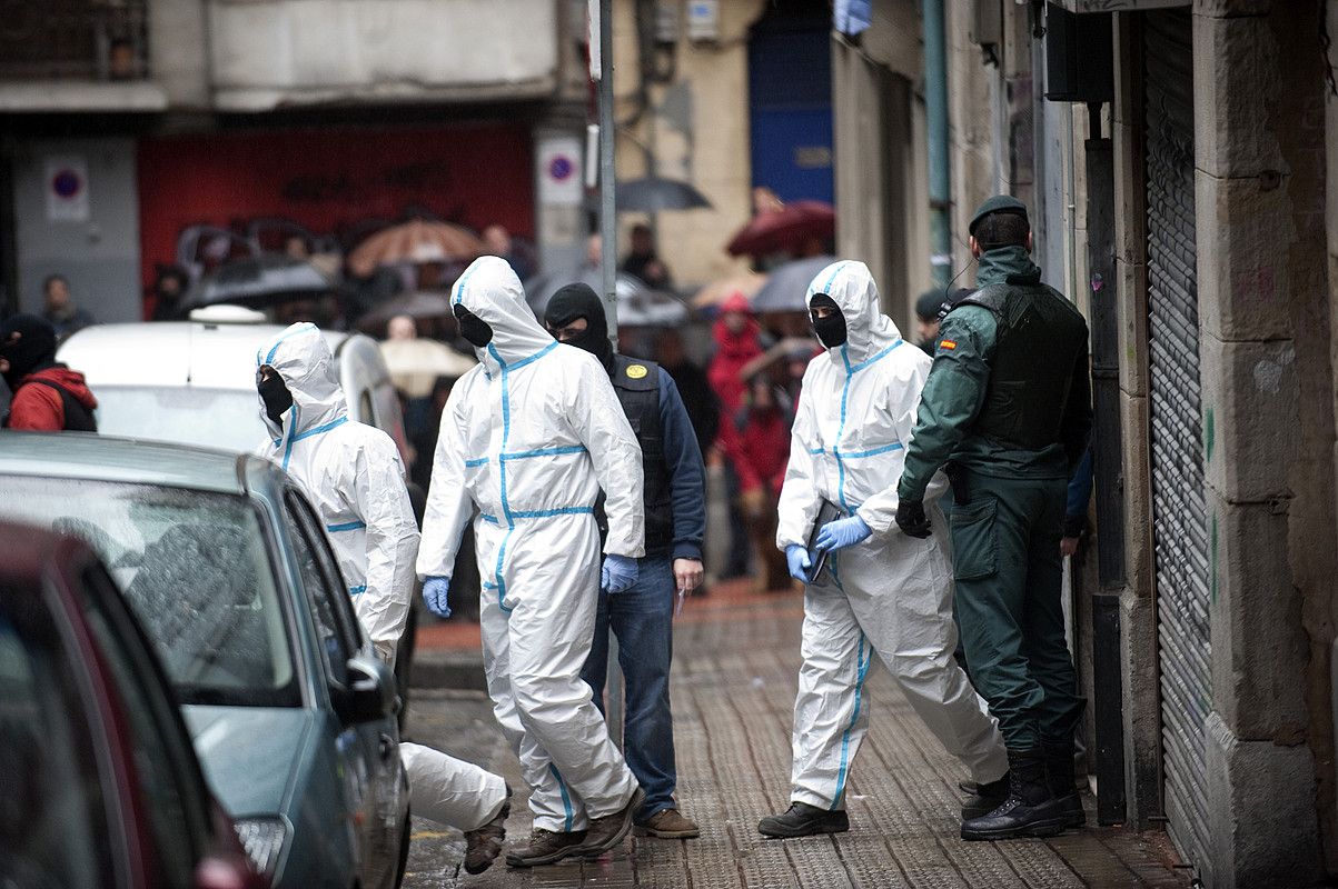 Guardia zibileko kide batzuk, atzo, polizia operazioan miatutako Bilboko etxebizitza batetik irteteko unean. MARISOL RAMIREZ / ARGAZKI PRESS.