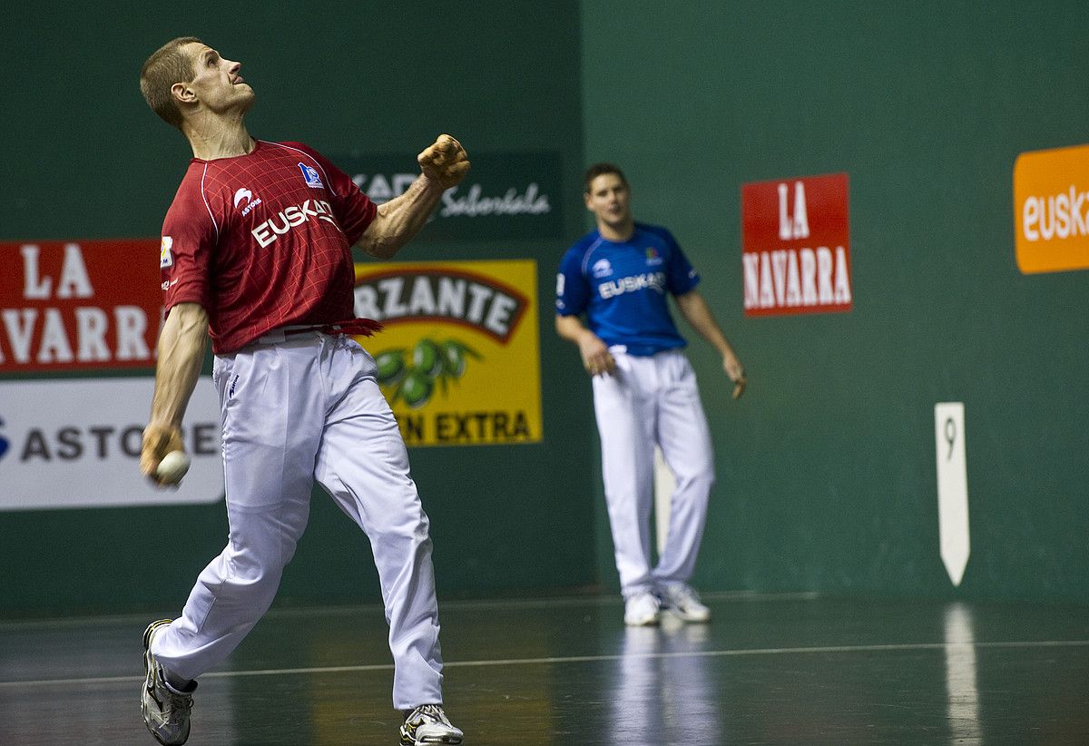 Aritz Laskurain pilota astintzen, eta atzean, Patxi Ruiz, atzo, Iruñeko Labrit pilotalekuan. JAGOBA MANTEROLA / ARGAZKI PRESS.