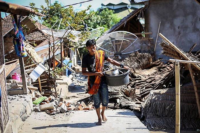 Indonesiako herritar bat, Lombok irlan izan den lurrikarak utzitako eraikin hondakinen artetik oinez. EFE