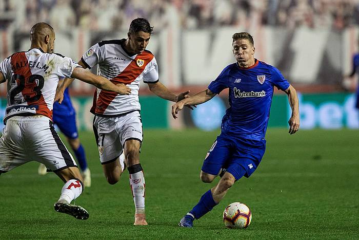 Iker Muniain Athleticeko jokalaria, Rayoko bi jokalariren aurrean baloia gidatzen. RODRIGO JIMENEZ, EFE