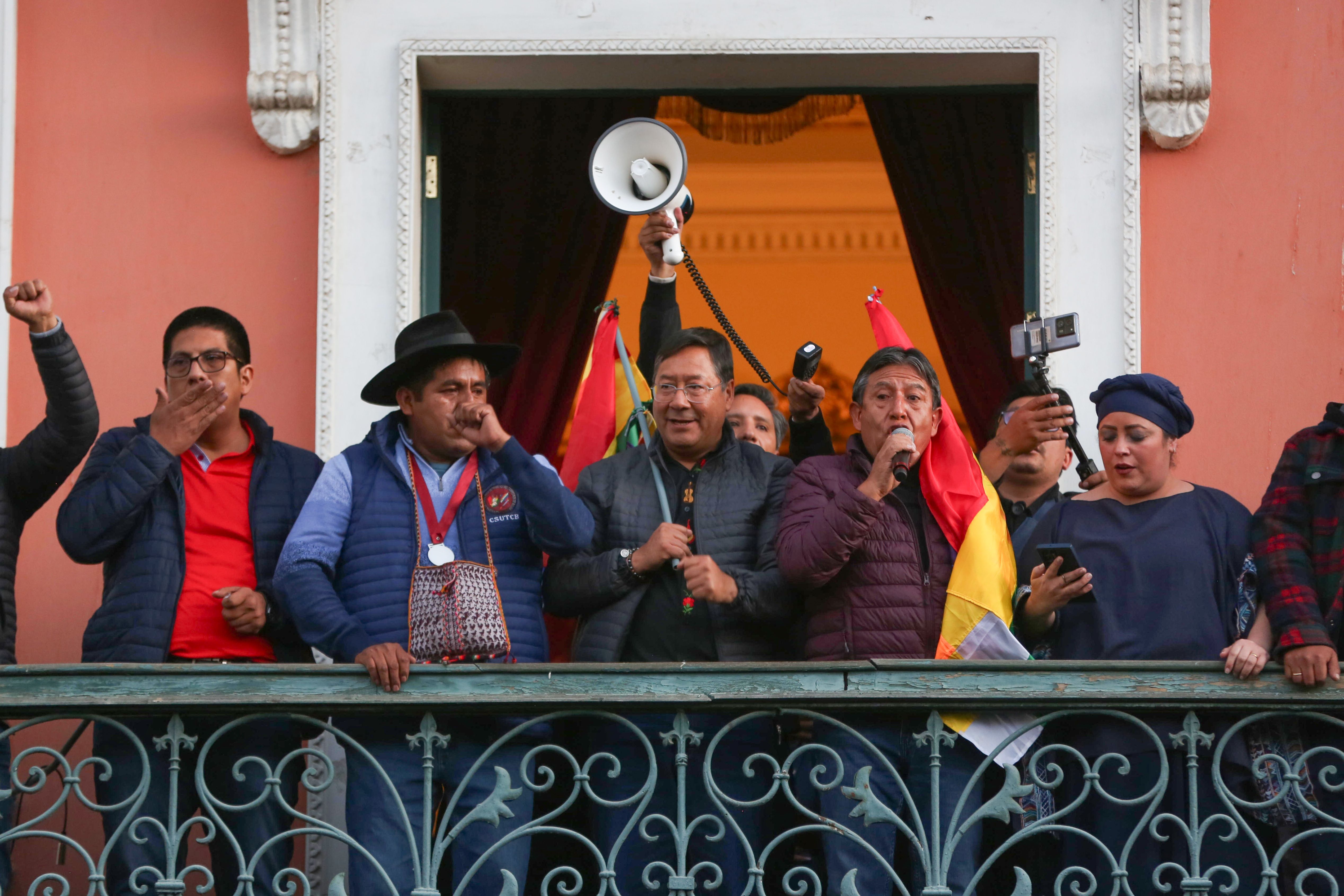 Luis Arce Boliviako presidentea, erdian, eta David Choquehuanca presidenteordea mikrofonoarekin, estatu kolpe ahaleginak huts egin ondoren, gobernuaren egoitzako balkoian.