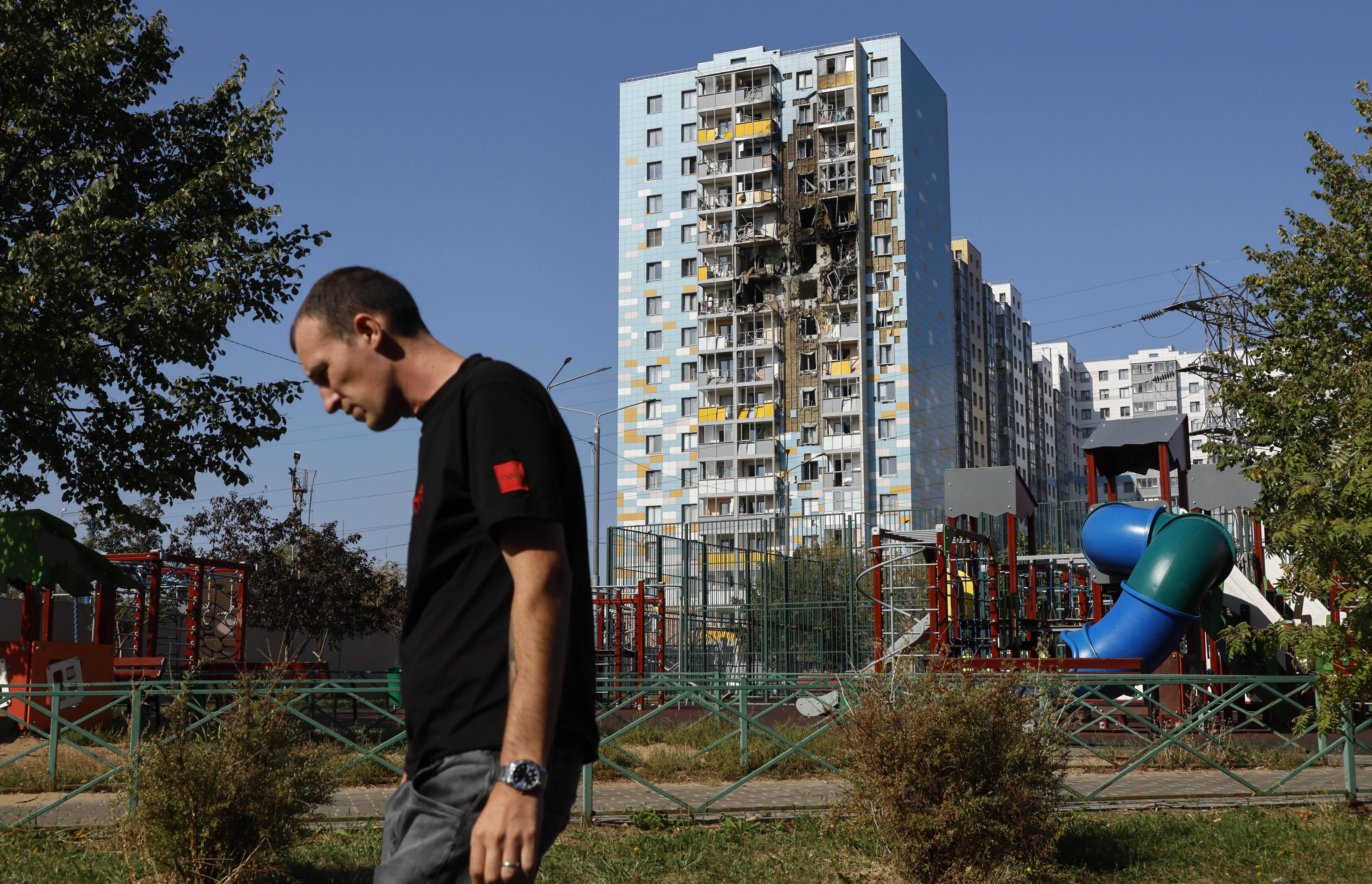 Errusiako herritar bat, Ramenskoie hirian, iragan asteartean; Ukrainako armadaren drone batek eragindako kalteak agertzen dira haren alboko eraikinean. YURI KOCHETKOV / EFE