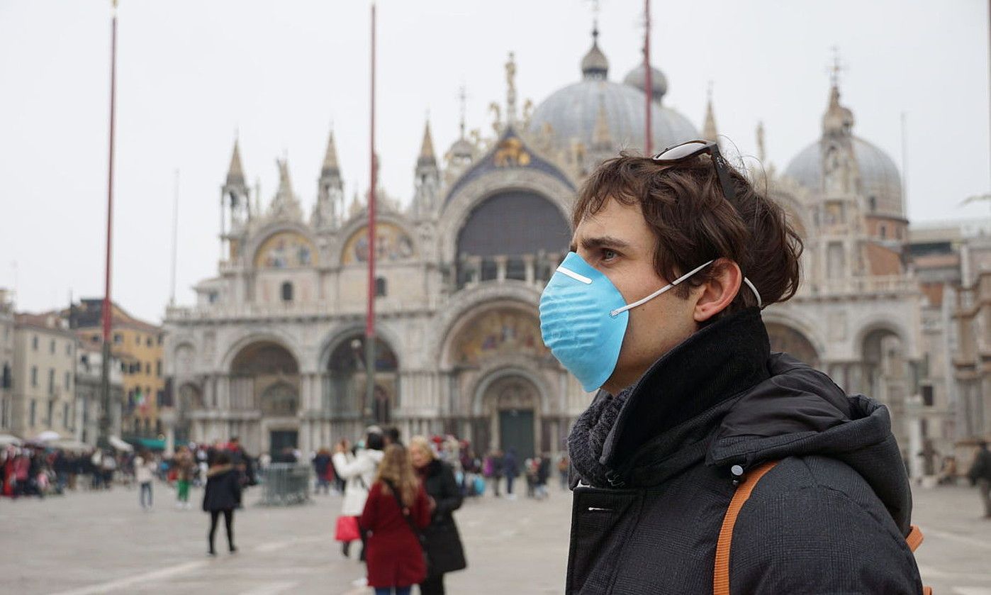 Turista bat Veneziako San Markos plazan, atzo, ahoa estalita. ANDREA MEROLA / EFE.