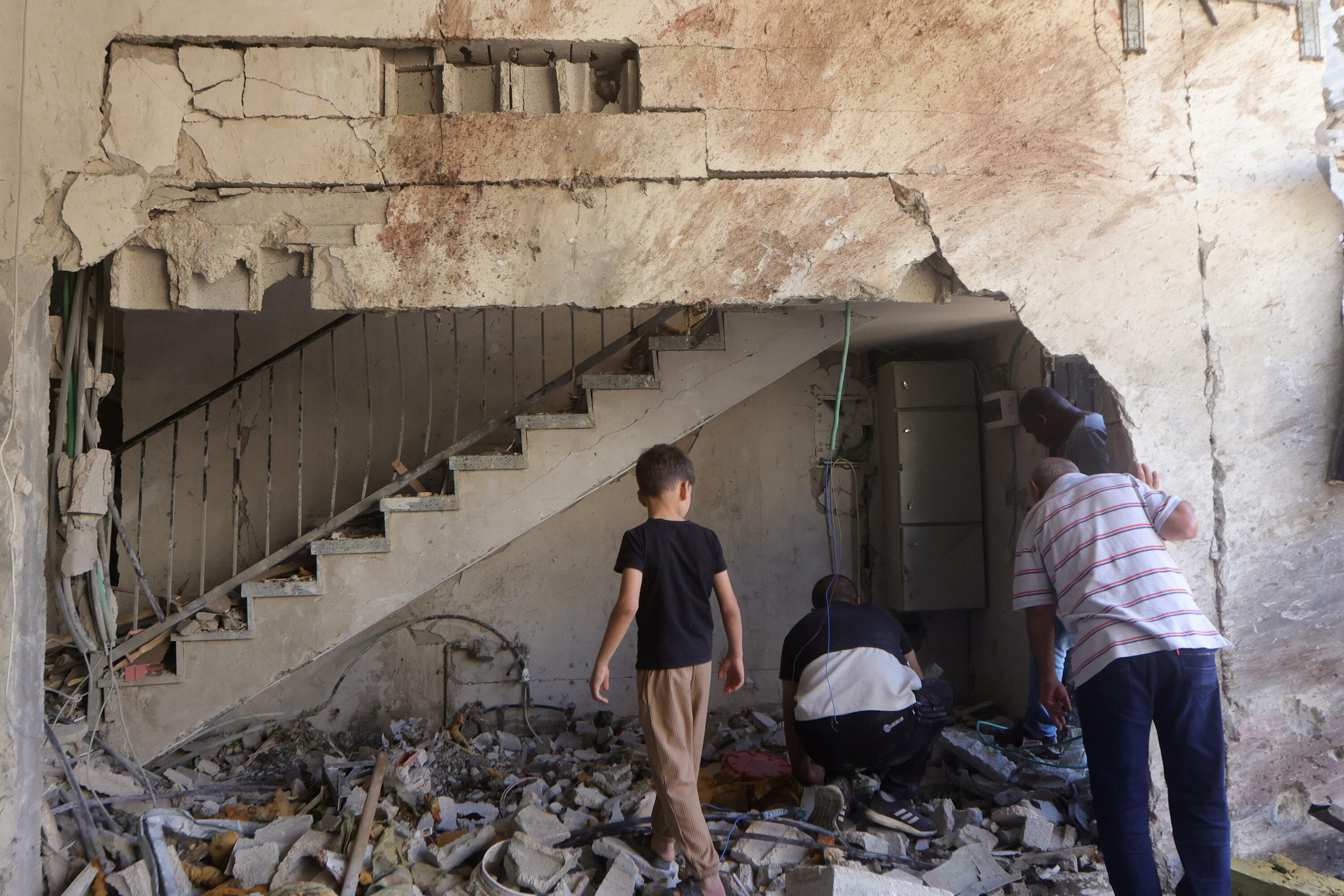 Palestinar batzuk bonbardaketak eragindako arrastoak garbitzen, gaur, Tulkaremen (ZIsjordania). ALAA BADARNEH / EFE