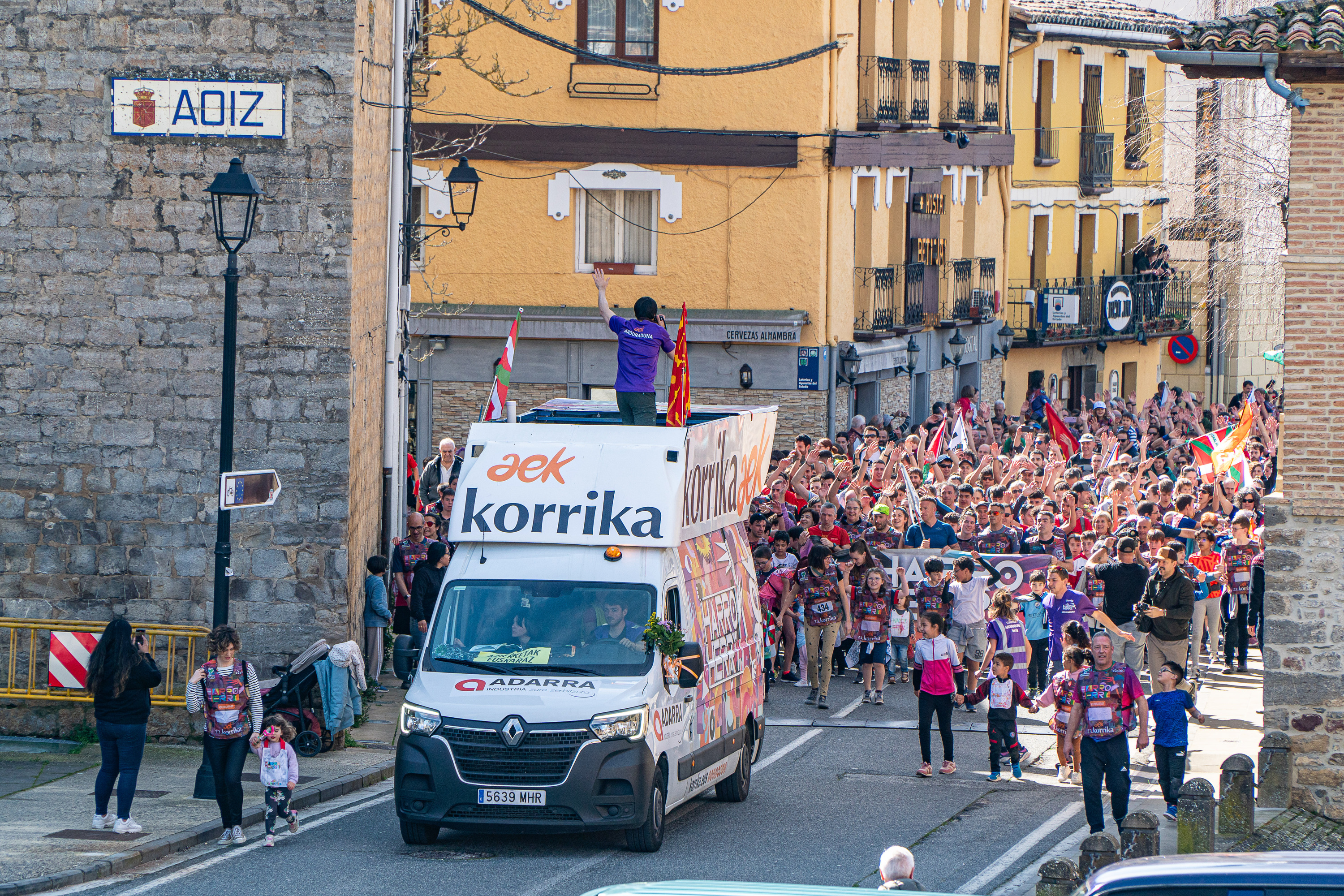 Korrikaren furgoneta atzean jendetza duela, Agoitzen, martxoan. AITOR KARASATORRE / FOKU