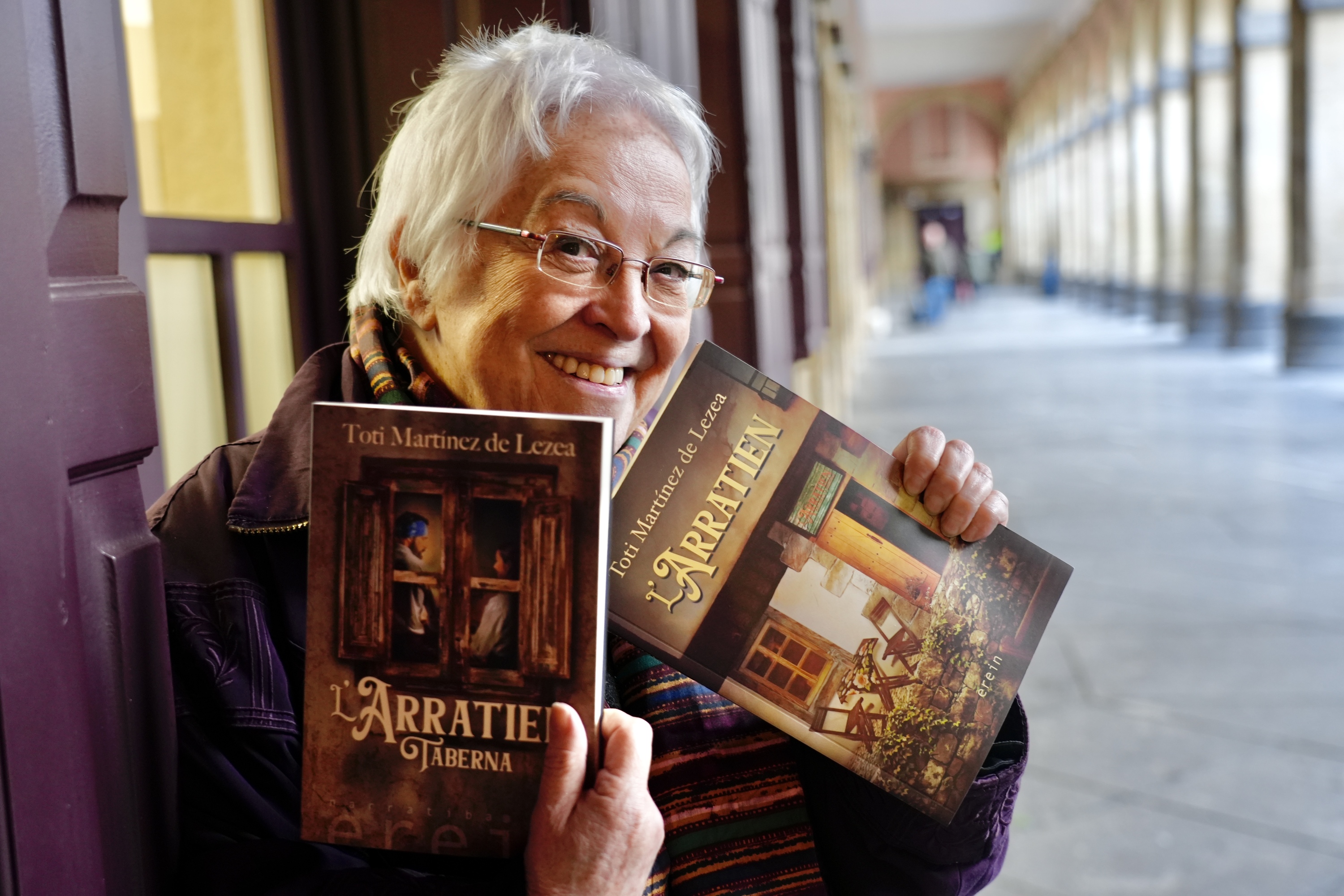 Toti Martinez de Lezea, 'L'Arratien taberna' eleberriaren aleak eskuetan dituela. ANDONI CANELLADA / FOKU