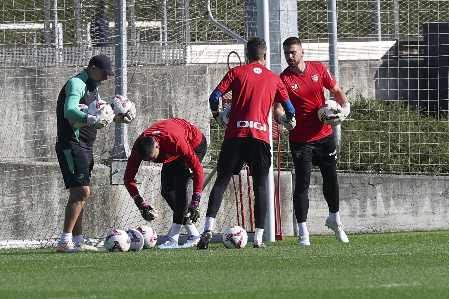 Julen Agirrezabala eta Unai Simon, elkarri bostekoa ematen, ondoan Alex Padilla hirugarren atezaina dagoela. LUIS TEJIDO / EFE