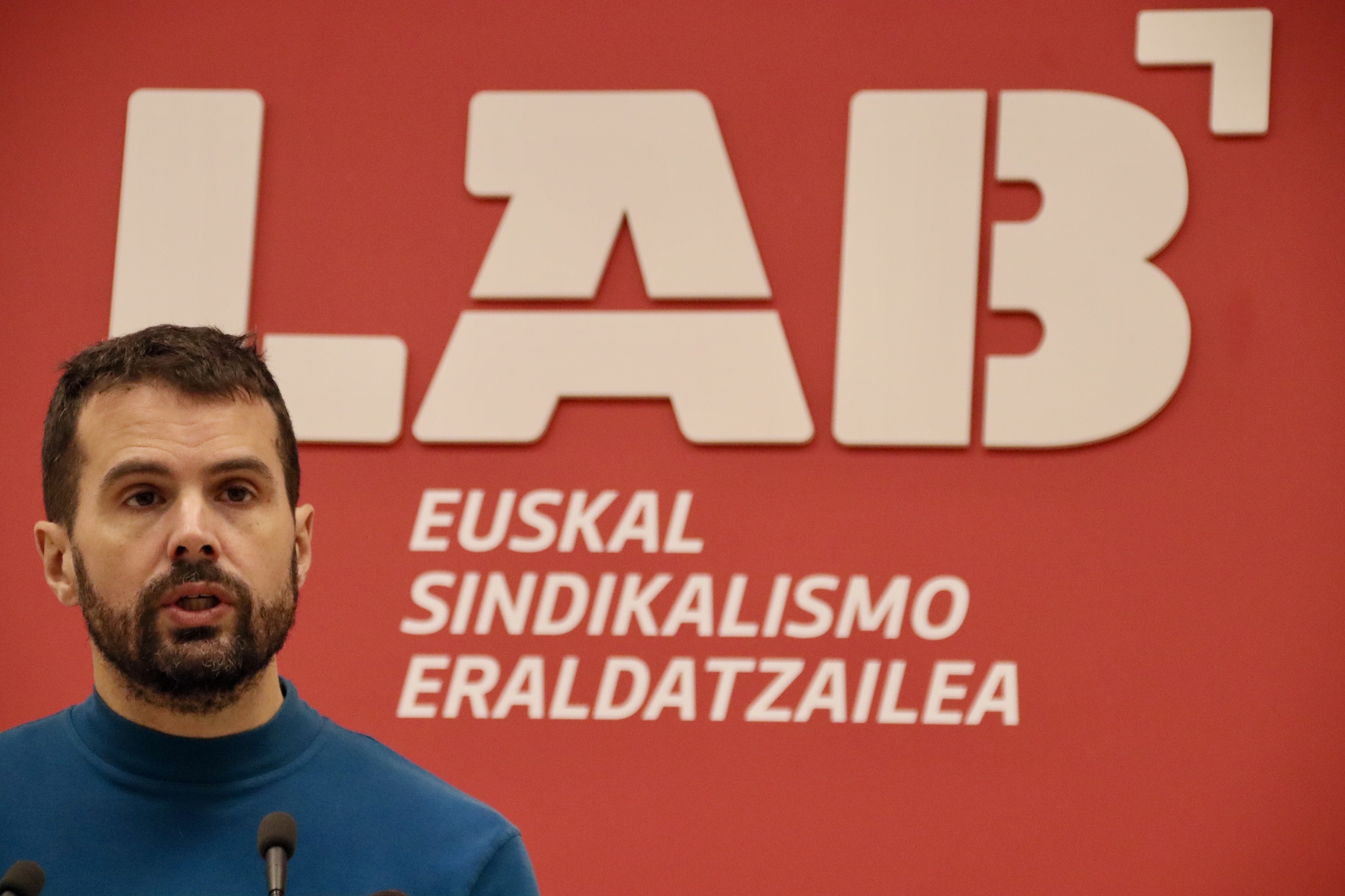 Igor Arroyo LABeko koordinatzaile orokorra, eta, atzean, sindikataren ikur eraberritua. LAB