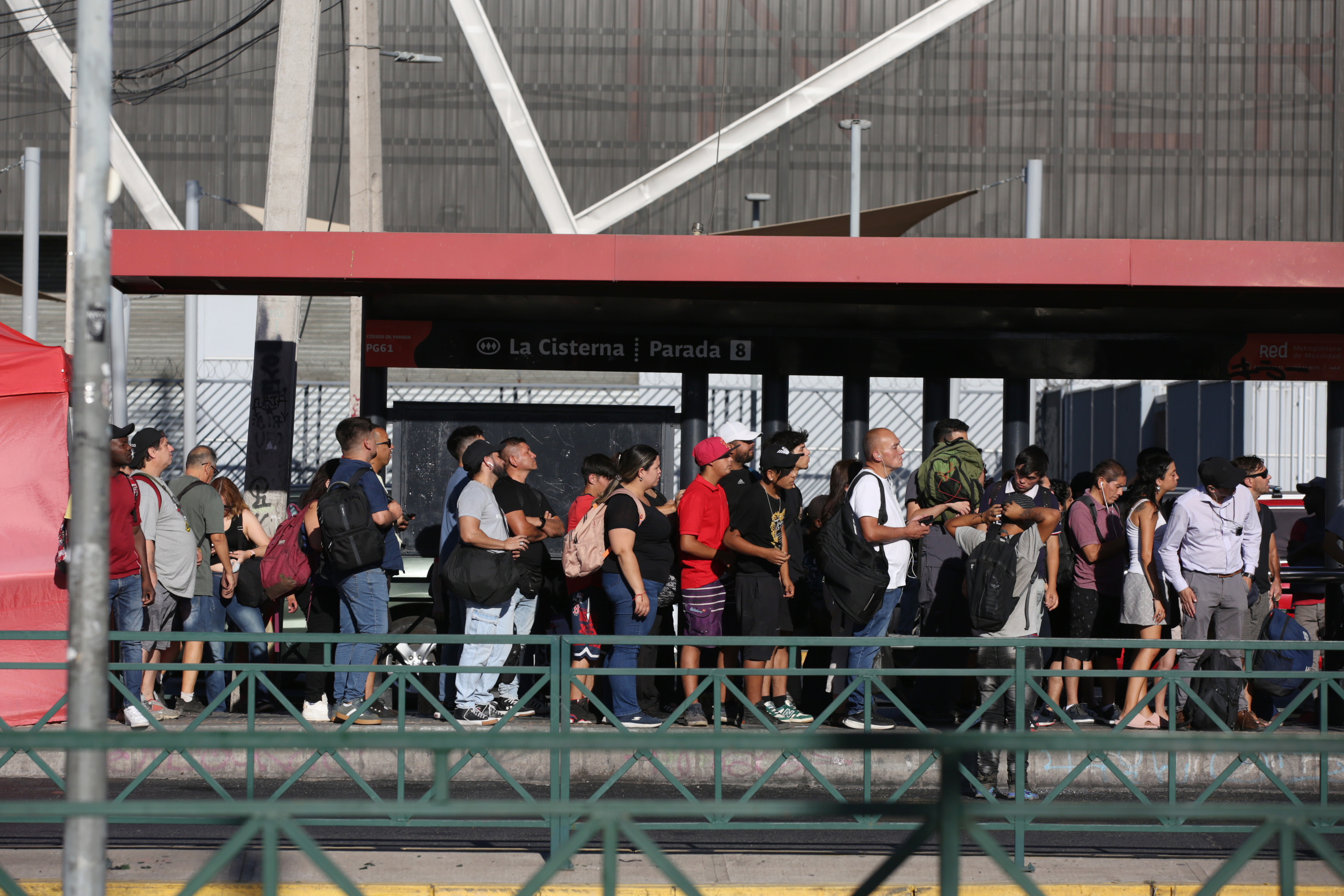 Herritarrak autobus baten zain, atzo, Santiago hiriburuan. ELVIS GONZALEZ / EFE