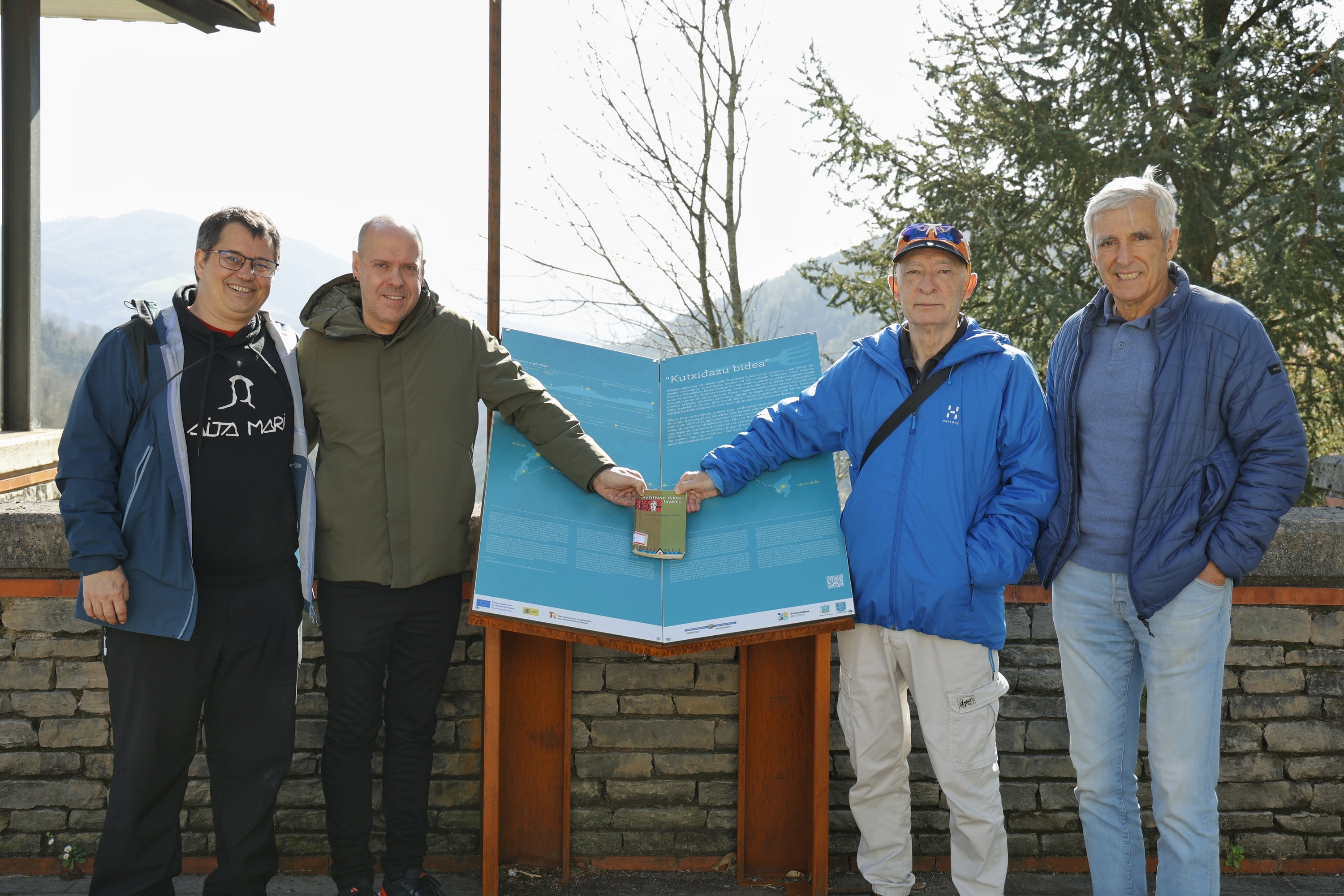 Brian Cullen, Luis Arana, Joxean Sagastizabal eta Inaki Irazabalbeitia, Alkizan, 'Kutsidazu bidea'-ren panel baten aurrean, liburuaren lehen edizioaren ale batekin. MAIALEN ANDRES / FOKU