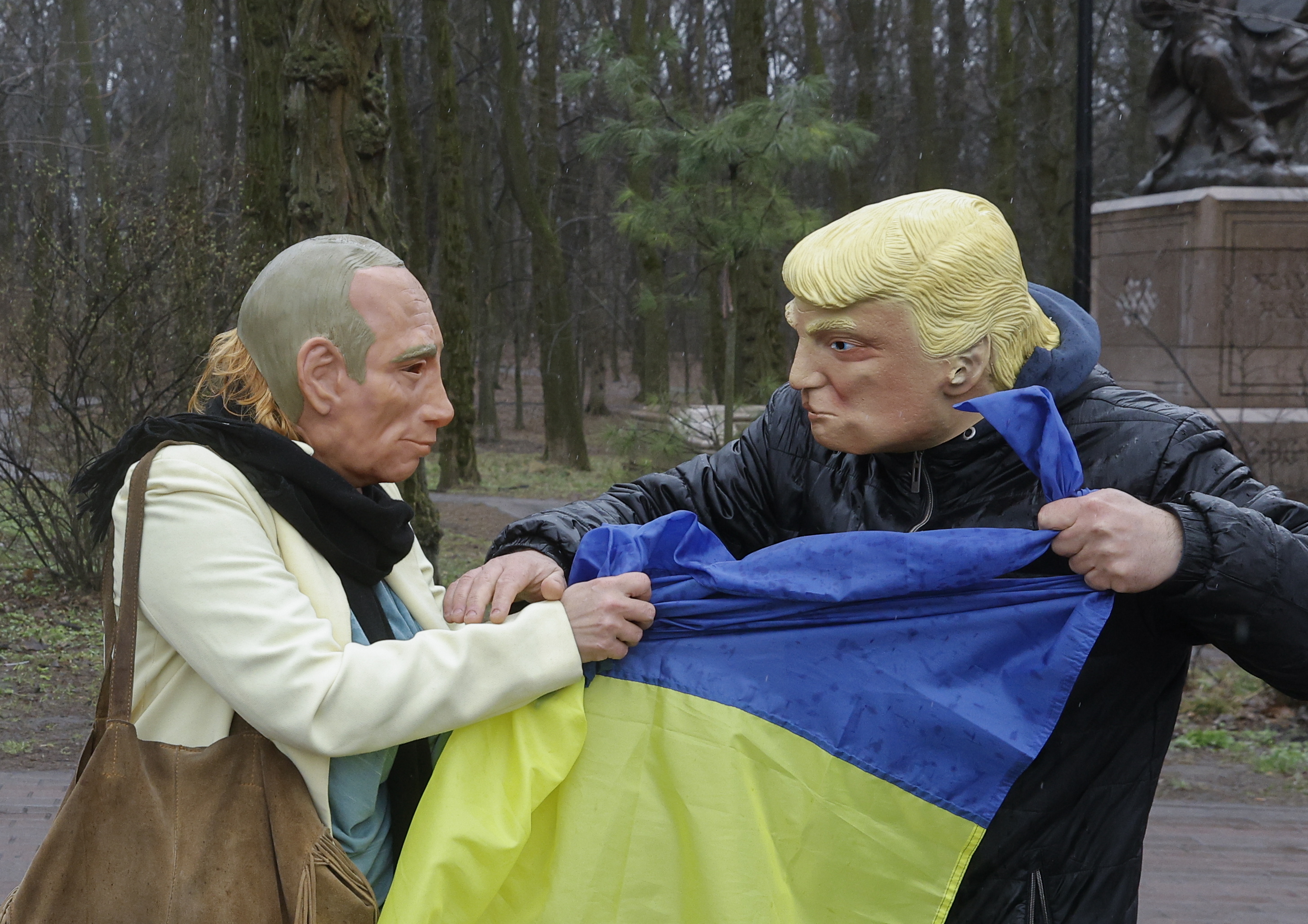 Bi pertsona protesta batean atzo Kieven, Putinen eta Trumpek maskarak jantzita dituztela. SERGEI DOLZHENKO / EFE