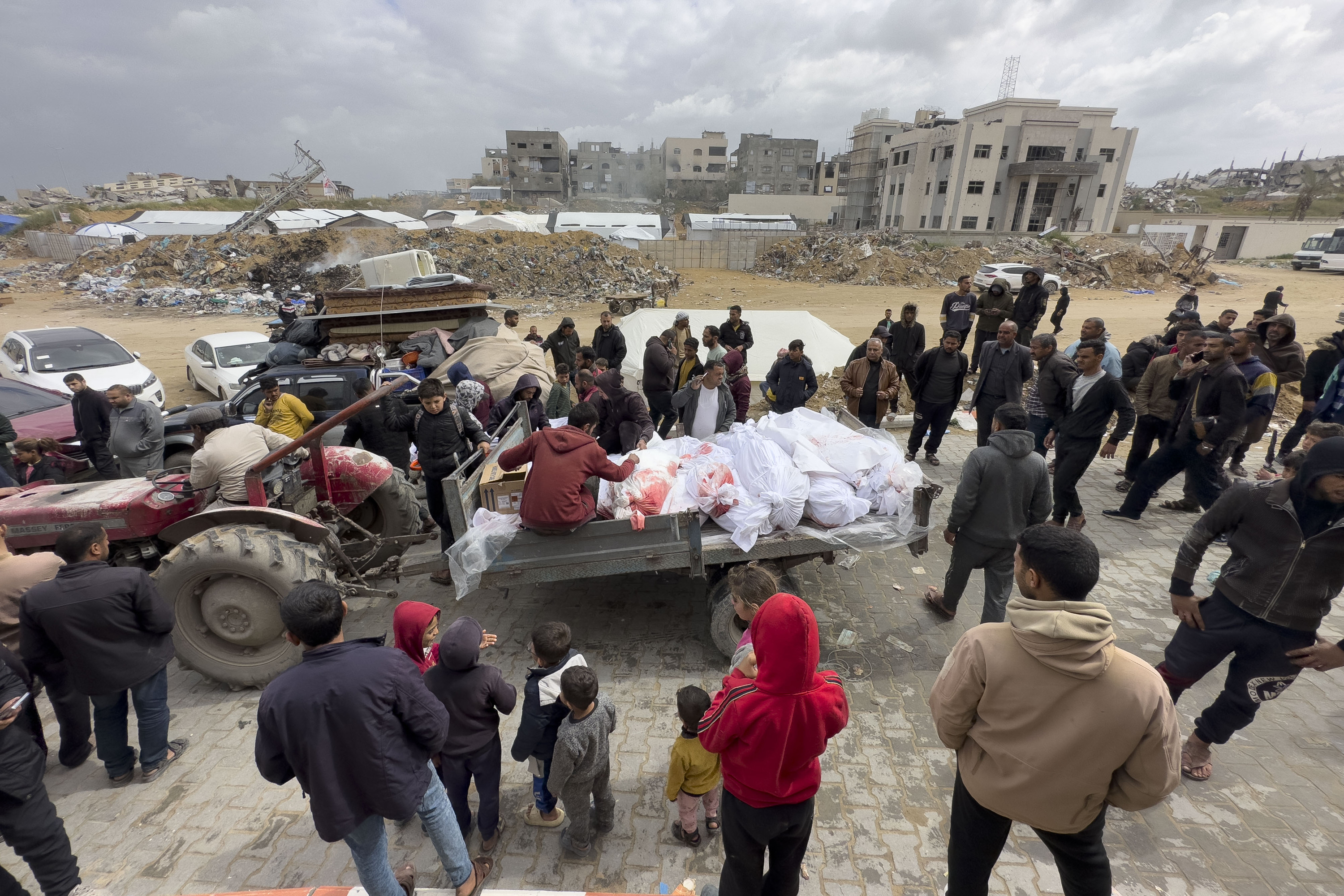 Zenbait palestinar gaur, gorpuak daramatzan traktore baten inguruan, Beit Laiha hirian, Gaza iparraldean. AHMAD AWAD / EFE