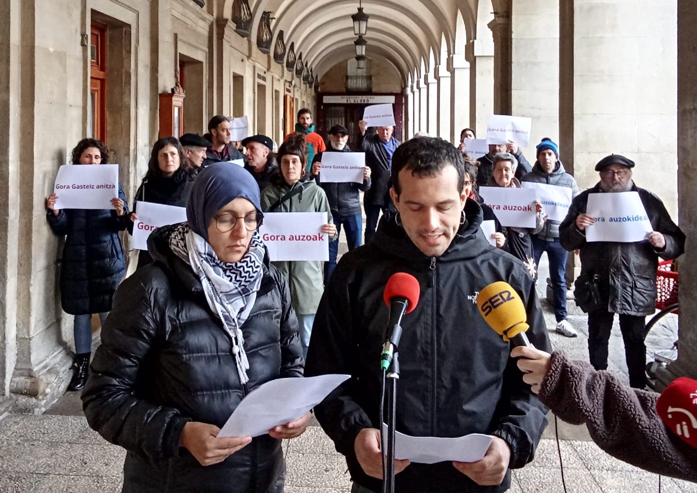 Tahir eta Suso adierazpenak egiten Gasteiz Anitzako kideen babespean, gaur, udaletxeko arkupeetan. BERRIA 