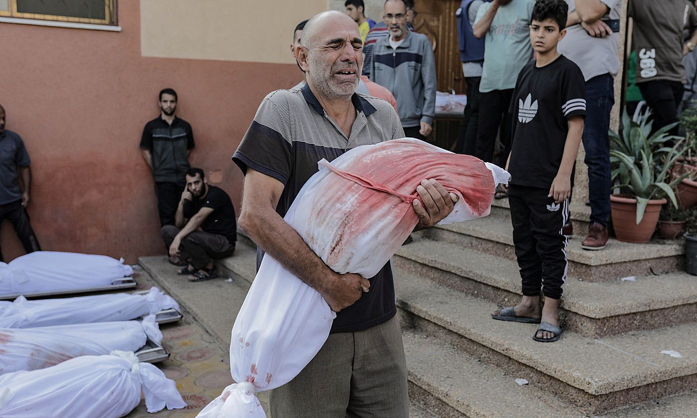 Gizon bat gorpu bat besoetan duela, atzo, Khan Yuniseko ospitale batean kanpoaldean. Israelek dozena bat inguru lagun hil zituen, atzo, han. HAITHAM IMAD / EFE.