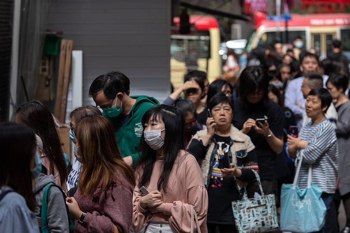 Jendea ilara egiten Hong Kongen, Ci bitaminadun pilulak eta ur botilak jasotzeko. JEROME FAVRE, EFE